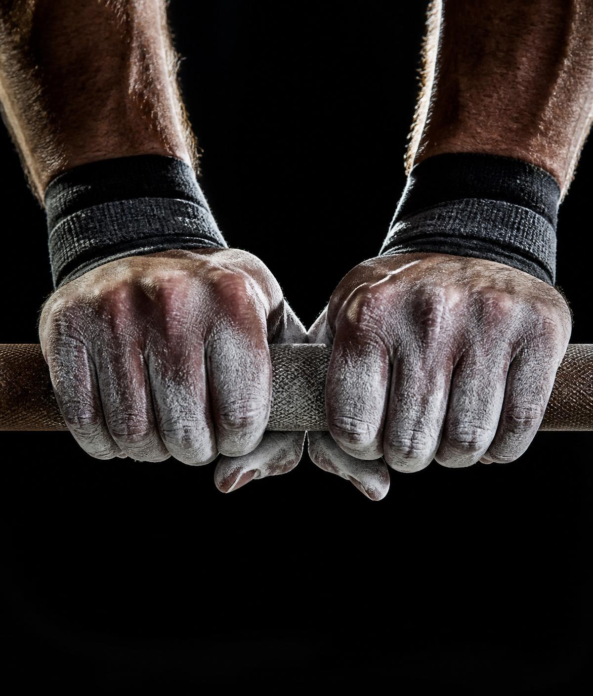 Chalked hands gripping a barbell